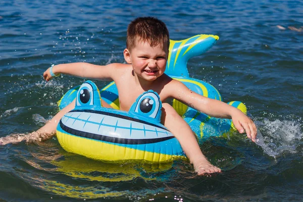 happy baby in inflatable baby boat at sea