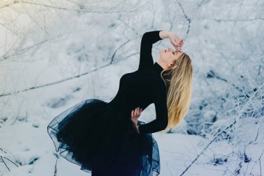 snow-clad ormanda siyah elbise dansçı