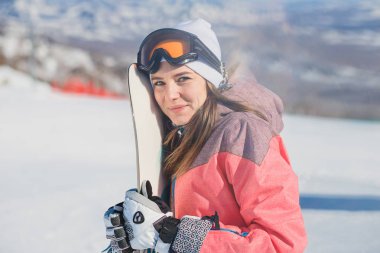 snowboard kamera dağlarda bakarak onun elinde güzel mutlu genç kadınla