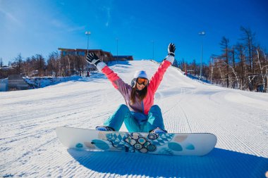 mutlu kadın snowboard oturur bir karlı dağ yamacında kış
