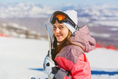mutlu bir kadın tutarak snowboard, snowboard, kış sporları