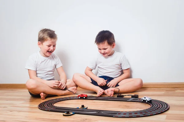 Dois Meninos Alegres Camisetas Brancas Começam Carros Brinquedo Dentro Casa — Fotografia de Stock