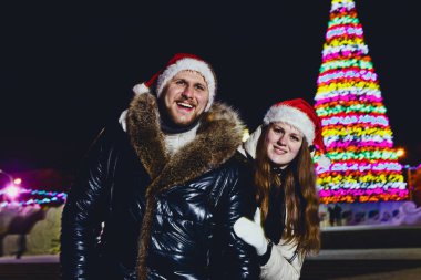 bir genç gülümseyen mutlu evli çift kırmızı kap Noel açık havada