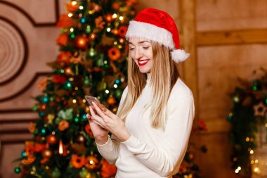 güzel gülümseyen kadın Smartphone vasıl arıyorum. Noel hediyesi. Her zaman temas halinde