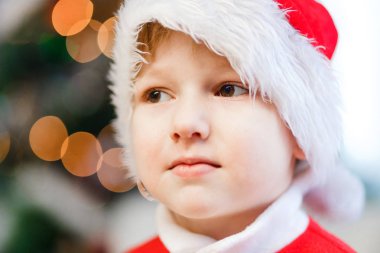 çocuğun kafasına kırmızı Noel Baba şapkası, ışıklar çelenk