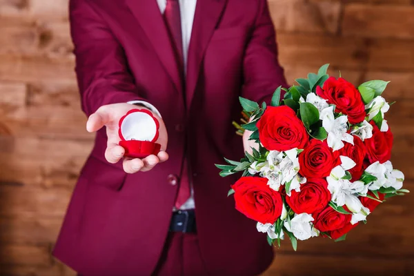 结婚戒指和花束在新郎手中 白色和红色玫瑰的婚礼花束 — 图库照片