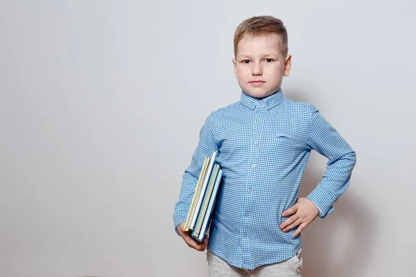 Menino Bonito Uma Camisa Azul Segurando Livro Sob Seu Braço — Fotografia de Stock