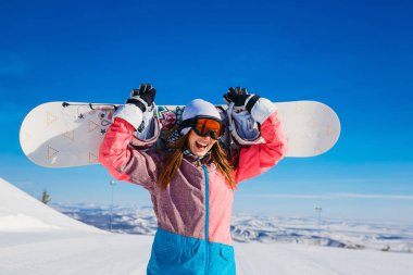 Kayak takım elbise ve gözlük mutlu neşeli kadın snowboard kışın onun elinde tutar. Aşırı spor