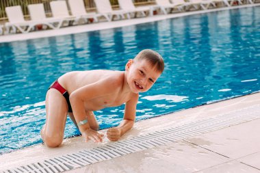 altı yaşında çocuk şort yüzme içinde açık havuzdan tatil olur. Çocuk ve yaz