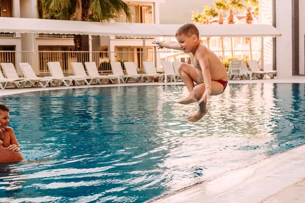 Летний Загорелый Мальчик Прыгает Ноги Заправлены Открытый Бассейн Курорте Семейный — стоковое фото