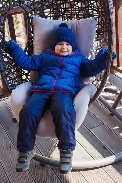 Счастливый Четырехлетний Мальчик Весной Лежит Висячем Плетеном Кресле Улице — стоковое фото