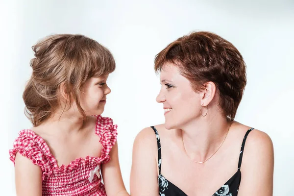 幸福的母女俩在白色的背景上互相看着对方 0岁的女子和6岁的女儿面面相觑 — 图库照片
