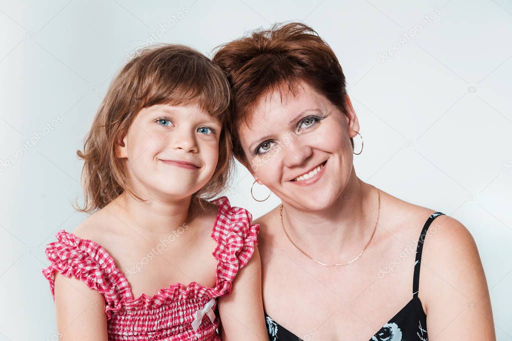 happy smiling mother and daughter together close on white background. thirty-year-old woman and six-year-old girl