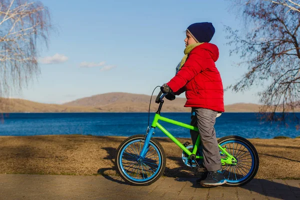 ilkbaharda göl kenarında iki tekerlekli bisiklet bebek