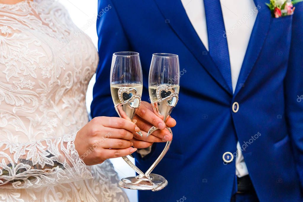 glasses of champagne in the hands of the newlyweds