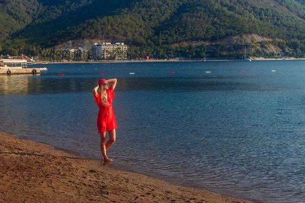 Glad ung kvinna i röda stranden tunika och bandana står vid havet, Turkiet — Stockfoto