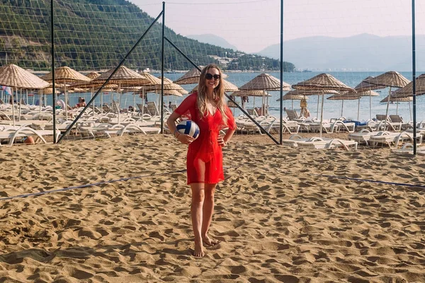 Leende kvinna i Strandklänning med bollen på sand, semester — Stockfoto
