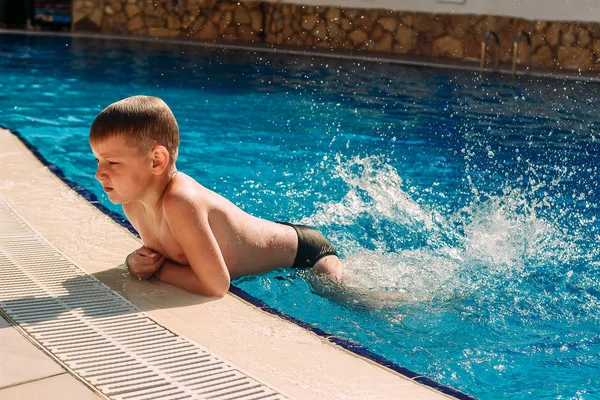 Έξι-έτος-παλαιό αγόρι κολύμπι στην εξωτερική πισίνα του ξενοδοχείου — Φωτογραφία Αρχείου