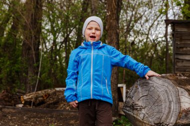 mavi bir windbreake yedi yaşındaki çocuk sevinci baharda bağırır.