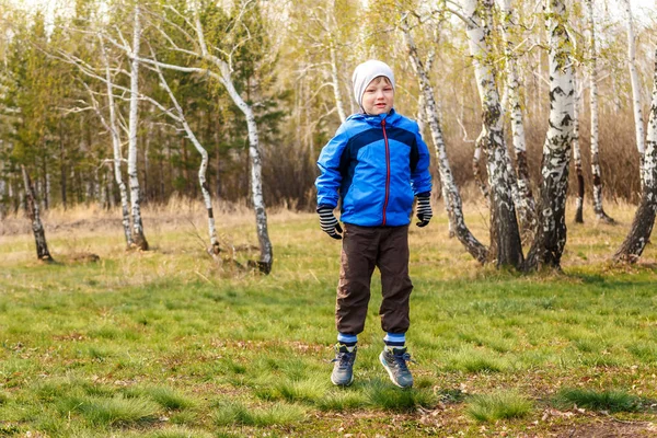 Шестирічний хлопчик стрибає на зеленій траві — стокове фото