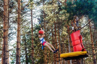 on-yıl-yaşlı beyaz kız sıkı bir ip üzerinde inişli çıkışlı bir kask içinde,