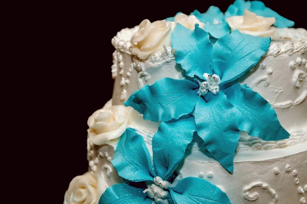 White wedding cake decorated with blue cream flowers on black background — Stock Photo, Image