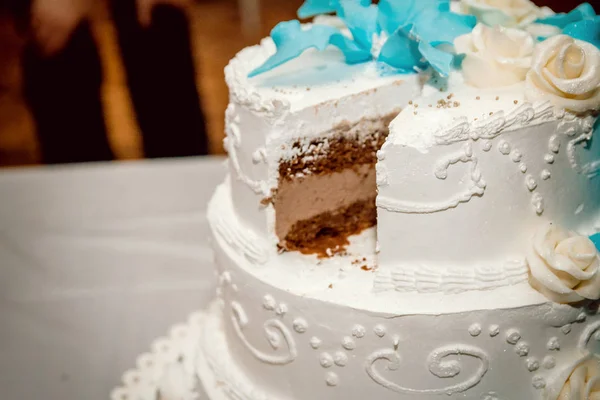 A large white wedding cake with a cut piece — Stock Photo, Image
