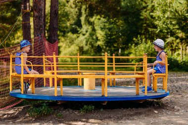 Yaz şapkalarında okul öncesi çocuklar yaz parkta büyük Carousel binmek