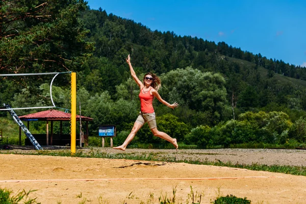 Saltare giovane donna sulla spiaggia in estate . — Foto Stock