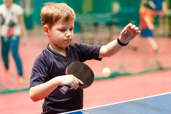 мальчик делает площадку для настольного тенниса, мяч для настольного тенниса в воздухе
.