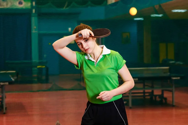 Caucasoide hermosa chica morena golpea fuera de la pelota de tenis de mesa en un gimnasio especializado . —  Fotos de Stock