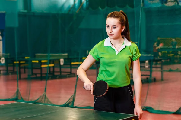 Patnáct let stará krásná Kavkazská dívka v zeleném sportovním sportu učit se na hraní stolního tenisu — Stock fotografie