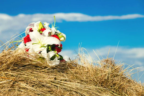 Букет невесты лежит в стоге сена — стоковое фото