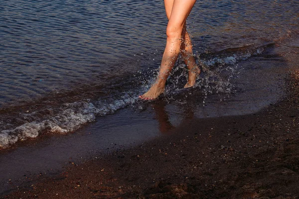 Pies de mujer en la playa — Foto de Stock