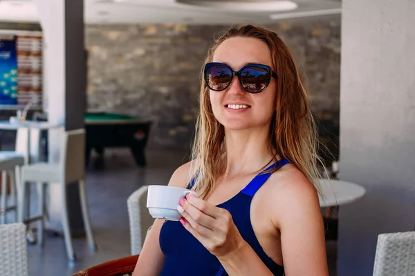 Glad trettio-årig kvinna med vått hår dricka kaffe i ett sommarkafé. — Stockfoto