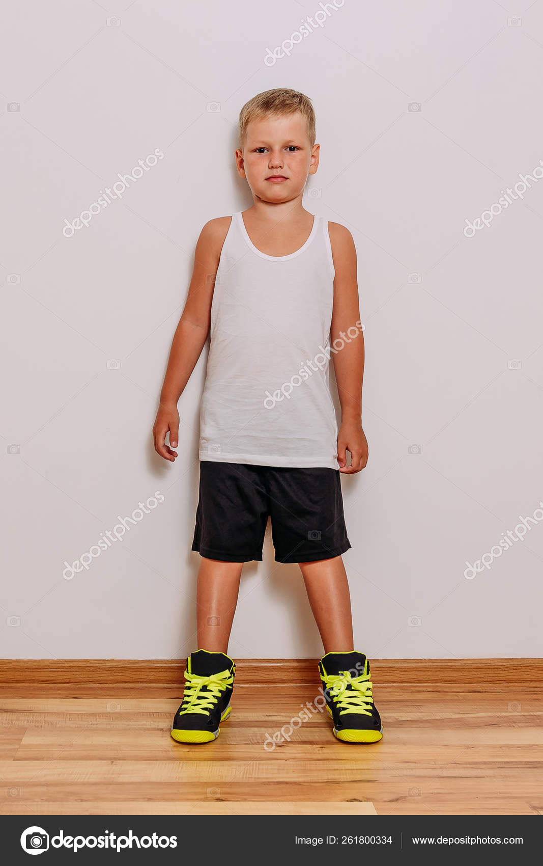 白いtシャツ 黒いバスケットボールのショートパンツとスニーカーを着た7歳の少年 ストック写真 C Ex3malka