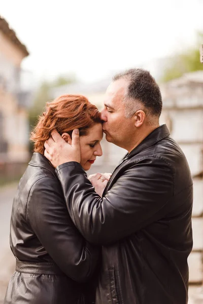 50-jähriger Mann küsst seine Frau sanft auf die Stirn — Stockfoto