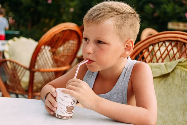 Мальчик пьет сок из трубочек — стоковое фото