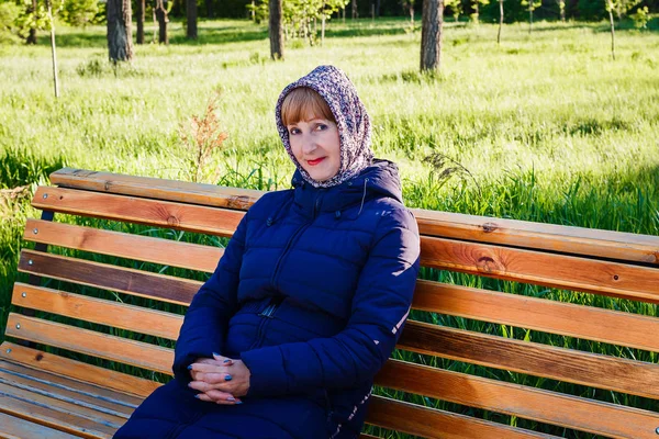 Красивая женщина пенсионерка сидит на скамейке — стоковое фото