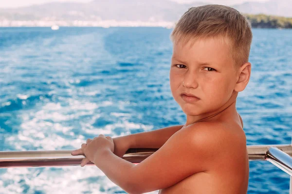 Загорелый мальчик на море летом — стоковое фото