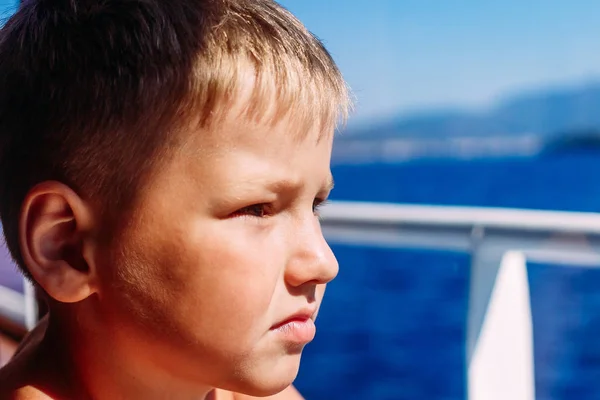 Лицо семилетнего мальчика, близкого друг другу. Ребенок у окна на корабле — стоковое фото