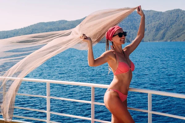 Leende kvinna i baddräkt och fladdrande tyg på fartyget i Turkiet på sommaren — Stockfoto