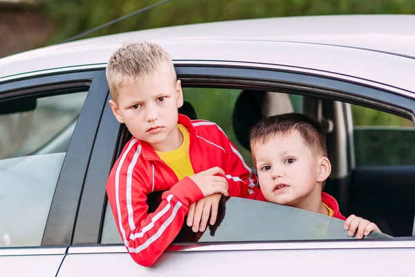 Çocuklar arabanın camından sana bakıyor. — Stok fotoğraf