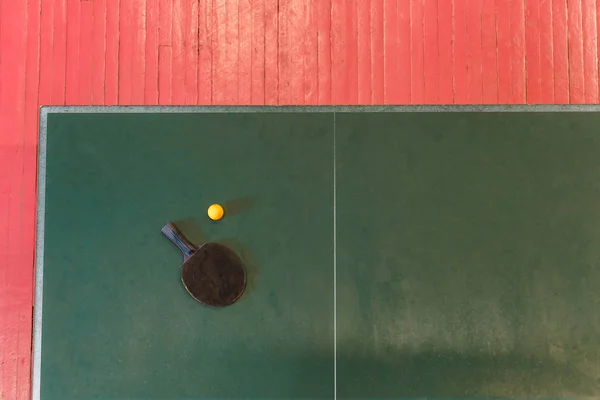 Raqueta y pelota de tenis en un tenis de mesa verde — Foto de Stock