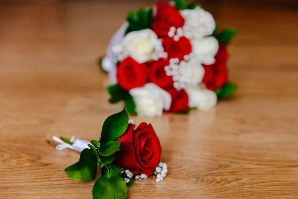 Ženichova boutonniere s červenými růsty a nevěstou kytici červených a bílých růží — Stock fotografie