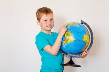 Yedi yaşındaki çocuk küreyi tutuyor