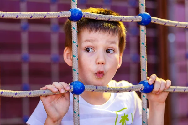 Смешной пятилетний мальчик на детской площадке — стоковое фото