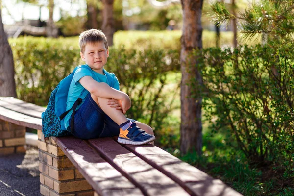 Счастливый улыбающийся мальчик в кроссовках и рюкзаке — стоковое фото
