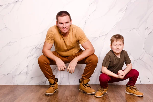 beyaz bir arka planda Baba ve oğul kamera içine bakmak