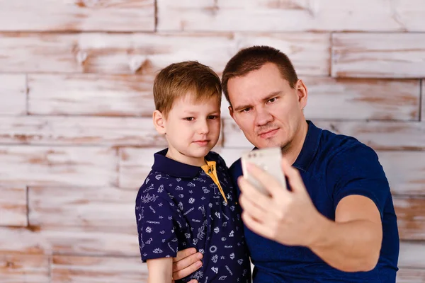 Батько і син фотографуються на смартфоні — стокове фото
